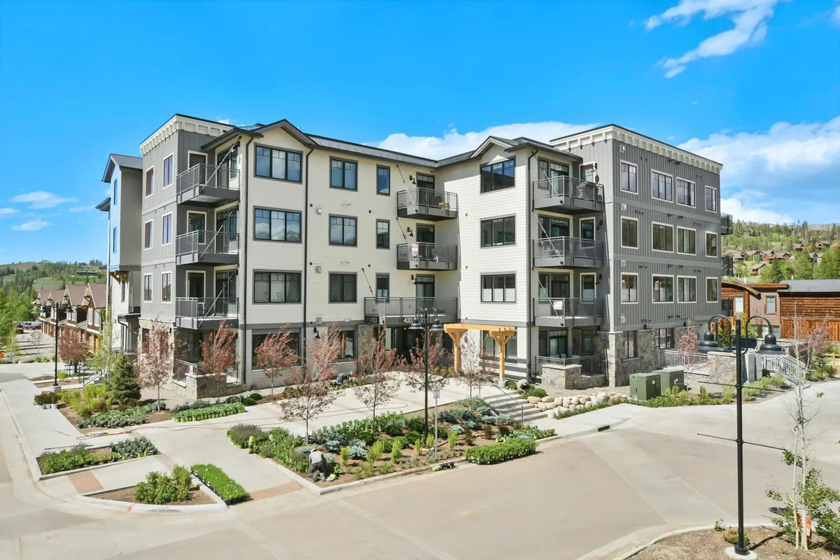 This image showcases the exterior of a modern residential building, featuring sleek architecture, landscaped gardens, and private balconies. The scene is inviting and highlights the upscale ambiance of the property, with sunset lighting enhancing the warmth and exclusivity of the environment.